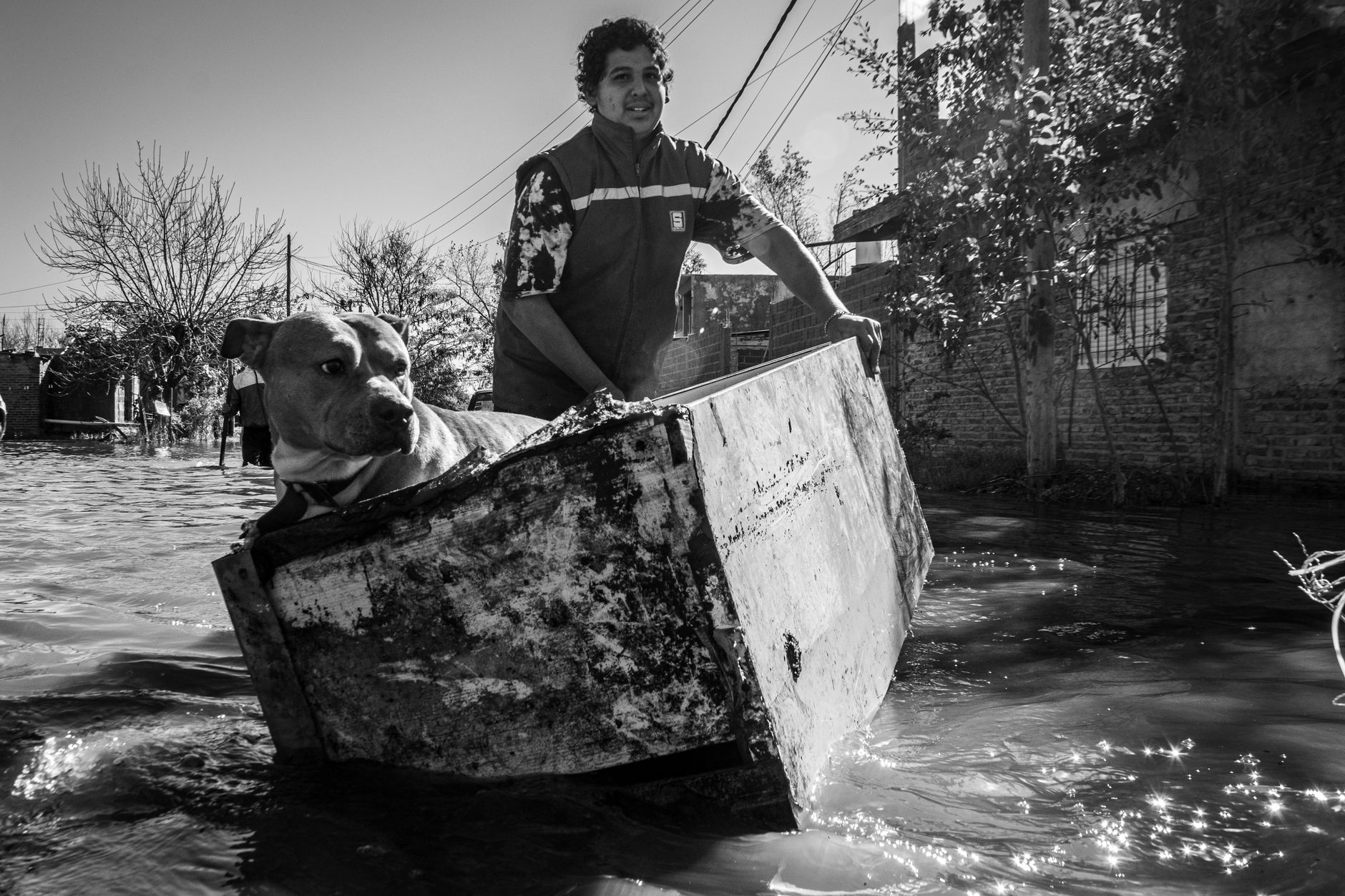 Man rescues dog using a makeshift boat during Buenos Aires flood.